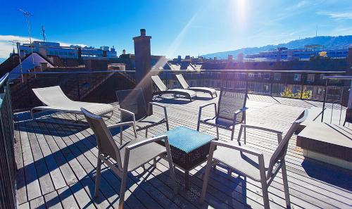 a group of chairs and tables on a roof at Premium Apartments by Livingdowntown in Zürich