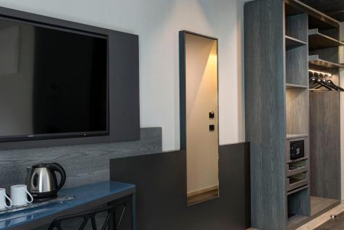 a dining room with a tv and a table with a table sidx sidx at iQ Hotel Milano in Milan