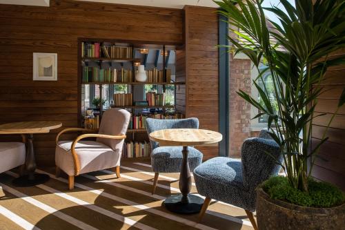 a library with chairs and a table and a book shelf at The Swan, Streatley, Berkshire in Streatley