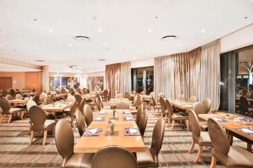 a dining room with wooden tables and chairs at RH Hotel Pretoria in Pretoria