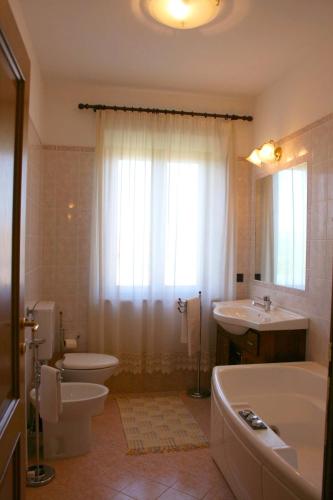 a bathroom with a tub and a toilet and a sink at Casa Felice in Lucignano