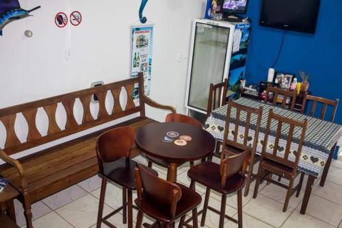 a dining room with a table and chairs and a bench at Paradise Hostel Ilha Grande in Abraão