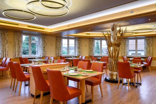 a dining room with tables and chairs and windows at Ringhotel Krone in Friedrichshafen