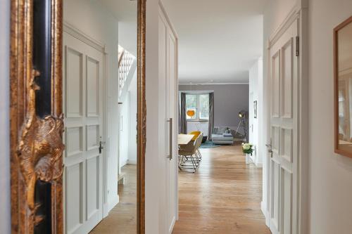 einen Flur mit Spiegel und ein Wohnzimmer in der Unterkunft FIRST im FIRST Sellin, Penthouse Paradies am Meer in Ostseebad Sellin