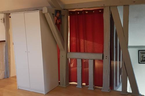 une chambre avec un escalier et un rideau rouge dans l'établissement Ciné Loft 55 m2 Centre Ville, à Châlons-en-Champagne