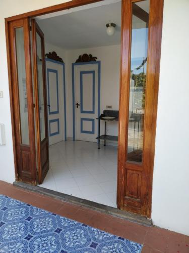 a doorway into a room with blue doors at La Casa al Mare Vulcano in Vulcano