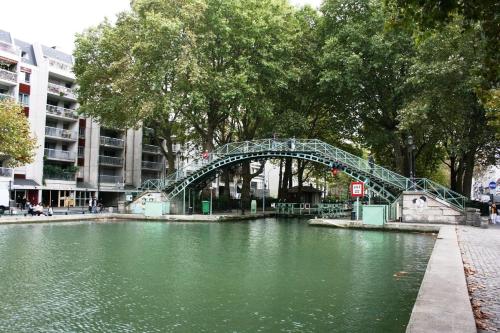 a bridge over a river in a city at Le Grand Quartier in Paris