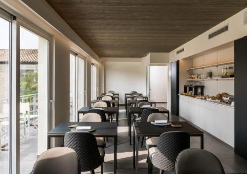 セニガッリアにあるFinis Africae Hotelのレストランのテーブルと椅子の列