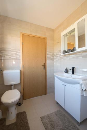 a bathroom with a toilet and a sink at OPG HORVAT SOBE ZA ODMOR in Daruvar