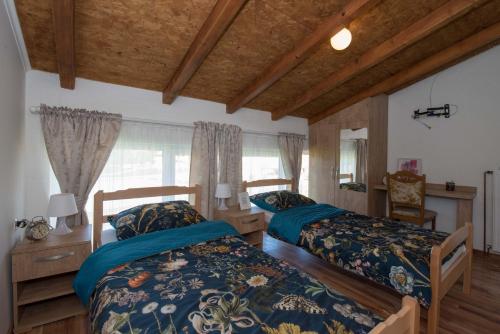 two beds in a room with wooden ceilings at OPG HORVAT SOBE ZA ODMOR in Daruvar