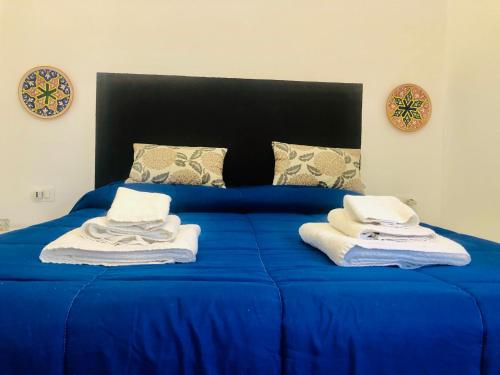 a blue bed with towels on top of it at Villa Mallandrino in Mondello