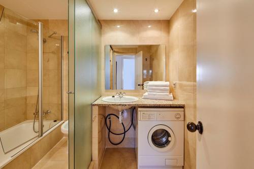 a bathroom with a sink and a washing machine at Apartamentos Centremar in L'Estartit