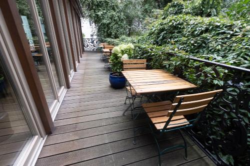 a wooden deck with benches and tables on a balcony at Merite Hotels Hamburg Altona GmbH in Hamburg