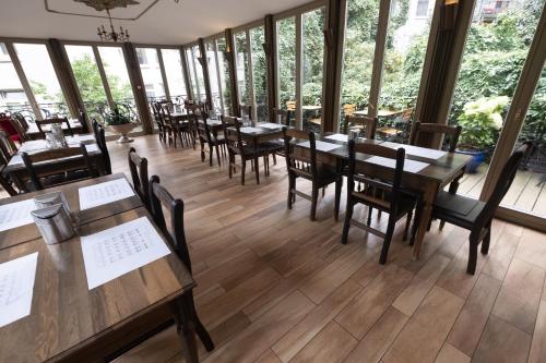 a restaurant with wooden tables and chairs and windows at Merite Hotels Hamburg Altona GmbH in Hamburg