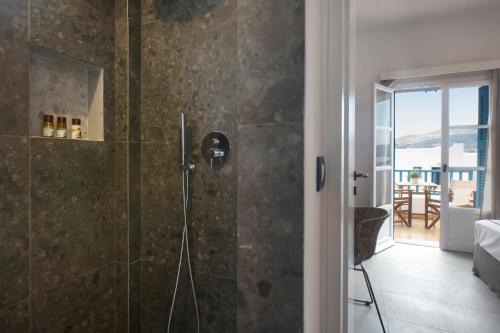 a bathroom with a shower with a view of the ocean at Kouros Village in Antiparos Town