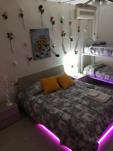 a bedroom with flowers on the wall and a bed with lights at B&B Planet in Montalbano Ionico