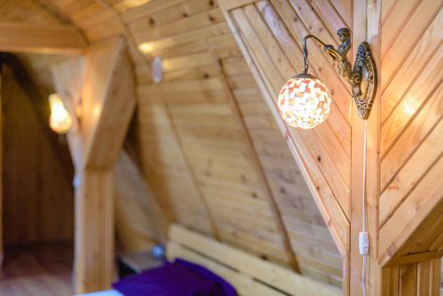 una luz en una pared de madera en una habitación en Wooden Attic Suite, en Brasov