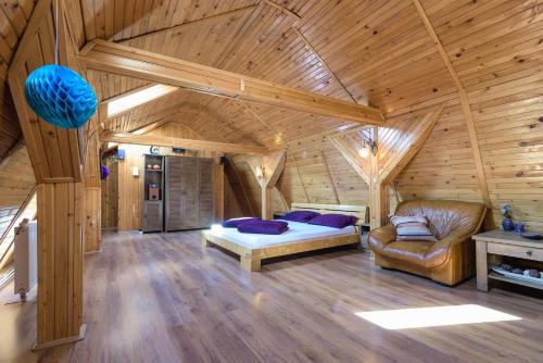 Wooden Attic Suite في براشوف: غرفة نوم في كابينة خشب بها سرير وأريكة