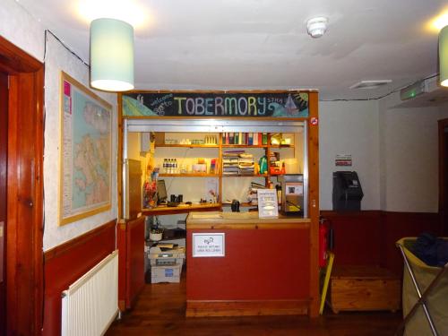 a restaurant with a counter with a sign that reads tobaccopotion at Tobermory Youth Hostel in Tobermory