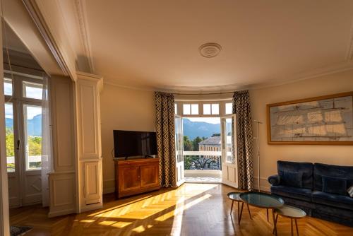 ein Wohnzimmer mit einem Sofa und einem TV in der Unterkunft L'Annexe du Château in Annecy