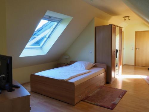 een slaapkamer met een bed en een dakraam bij Gasthof Erfurth in Sehnde