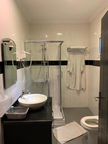 ブラザヴィルにあるCapital Hôtelのバスルーム(シンク、シャワー、トイレ付)