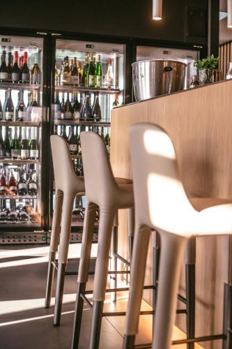 a row of white chairs in front of a bar at Mosella Suite Hotel in Sottomarina