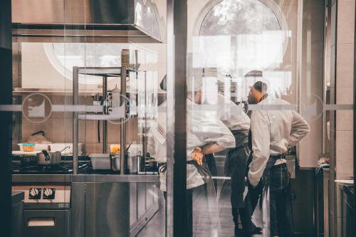 two chefs standing in a kitchen preparing food at Mosella Suite Hotel in Sottomarina
