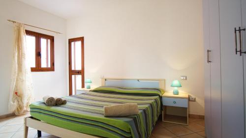 a bedroom with a bed and a table with two lamps at Le Gemelle di Cairoli in Santa Teresa Gallura
