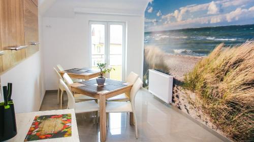 a dining room with a table and a painting of the beach at Dom Gościnny u Rekina in Łukęcin
