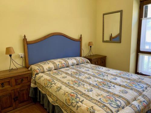 1 dormitorio con 1 cama grande y cabecero azul en BPIRINEOS-La Borda, en Benasque