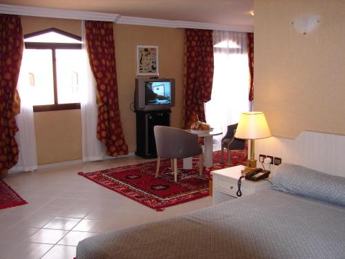 a bedroom with a bed and a tv in it at Hôtel Atlantique Panorama in Safi