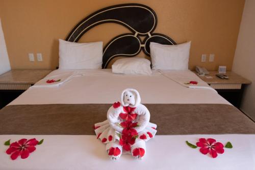 a bed with a doll sitting on top of it at Qualton Club Ixtapa All Inclusive in Ixtapa