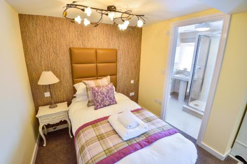 a small bedroom with a bed and a window at The George Hotel in Axminster
