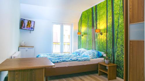 a room with a bed with a green wall at Dom Gościnny u Rekina in Łukęcin