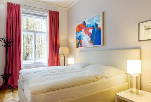um quarto com uma cama grande e cortinas vermelhas em Apartments Fuchsthallergasse em Viena