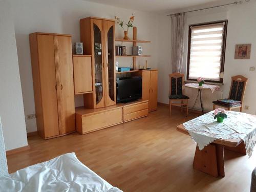 ein Wohnzimmer mit Holzmöbeln und einem Tisch in der Unterkunft Gästewohnungen Hennig in Markkleeberg