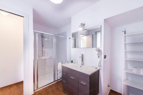 a white bathroom with a sink and a shower at Miralago Apartments Villa Rosa Lake View in Bellagio
