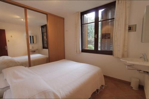 une chambre avec un lit, un lavabo et une fenêtre dans l'établissement Les Eucalyptus, à Bormes-les-Mimosas