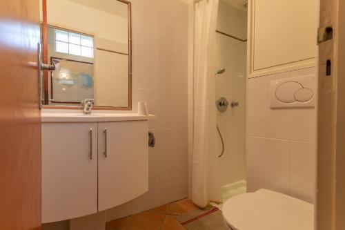 une salle de bain avec toilettes, lavabo et miroir dans l'établissement Les Eucalyptus, à Bormes-les-Mimosas
