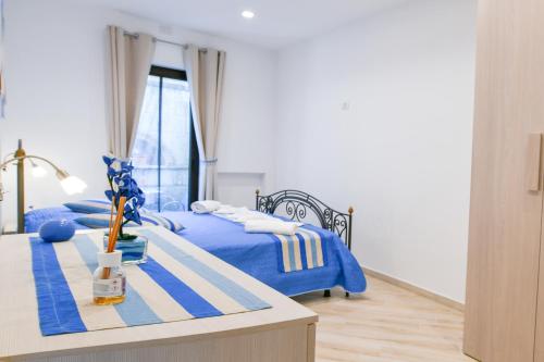 a bedroom with two beds with blue sheets and a table at Il Profumo di Capri in Massa Lubrense
