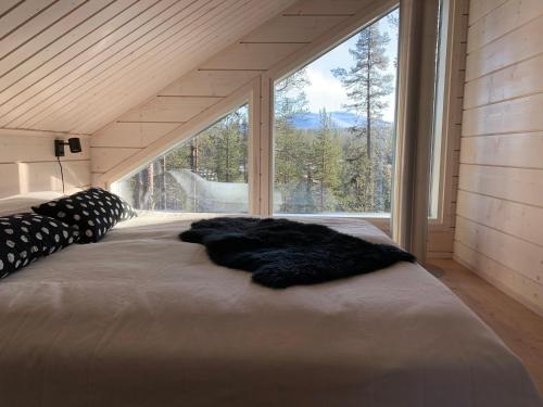 a large bed in a room with a large window at Villa LumiHelmi A & B in Äkäslompolo