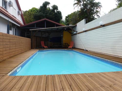 una gran piscina azul en una terraza de madera en Le Miougane, en Ravine des Cabris
