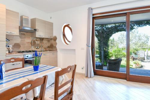 a kitchen with a table and a large sliding glass door at Il Profumo di Capri in Massa Lubrense