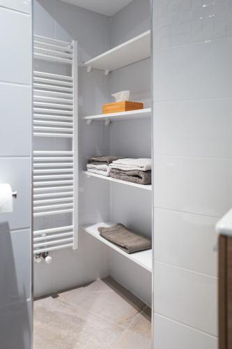 Elle comprend un dressing avec des murs blancs et des étagères blanches. dans l'établissement L'étoile d'Alice, à Étoile-sur-Rhône