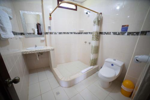 a bathroom with a shower and a toilet and a sink at Hostal Gladismar in Puerto Villamil