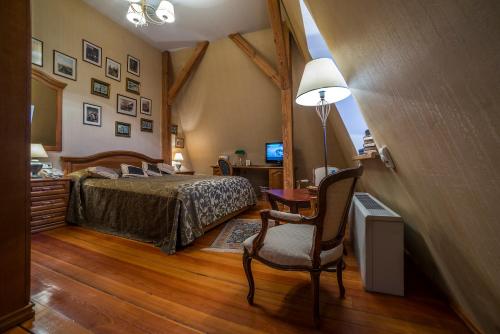 a bedroom with a bed and a table and a chair at Shakespeare Boutique Hotel in Vilnius