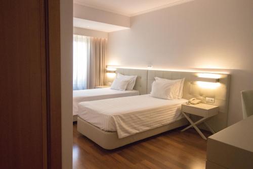 Una habitación de hotel con dos camas y una ventana. en Hotel Travel Park Lisboa, en Lisboa