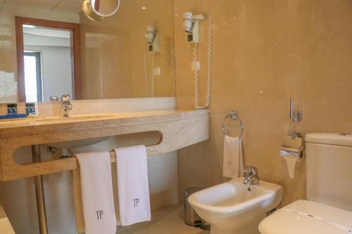 Un baño con lavabo, inodoro y espejo. en Hotel Travel Park Lisboa, en Lisboa