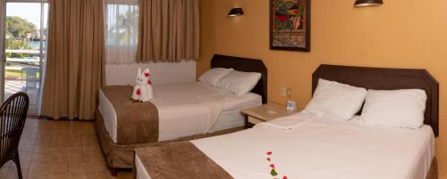 a hotel room with two beds and a balcony at Qualton Club Ixtapa All Inclusive in Ixtapa